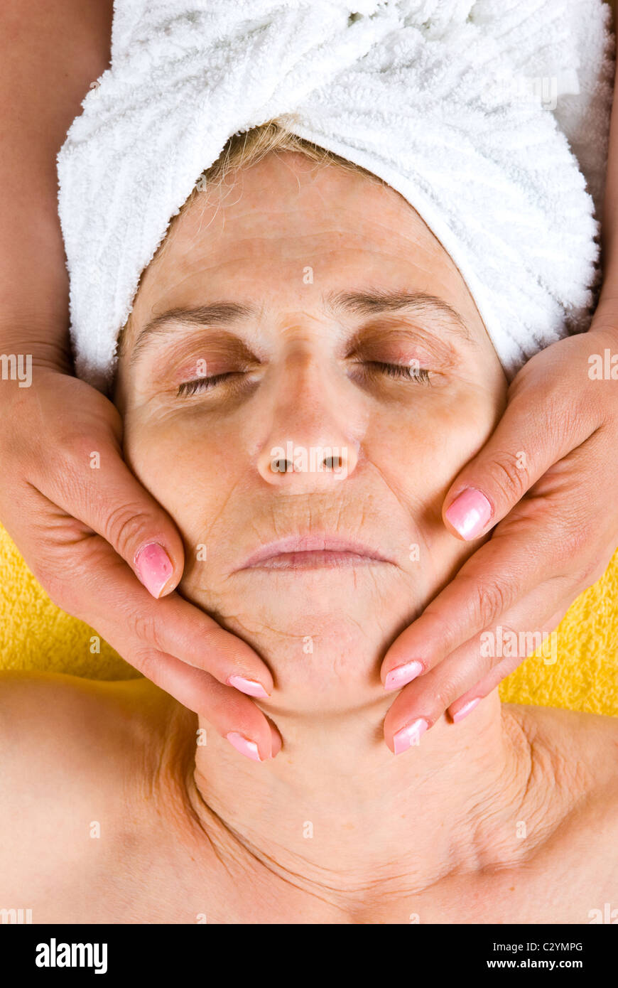 Senior woman receiving a facial massage at spa resort Stock Photo