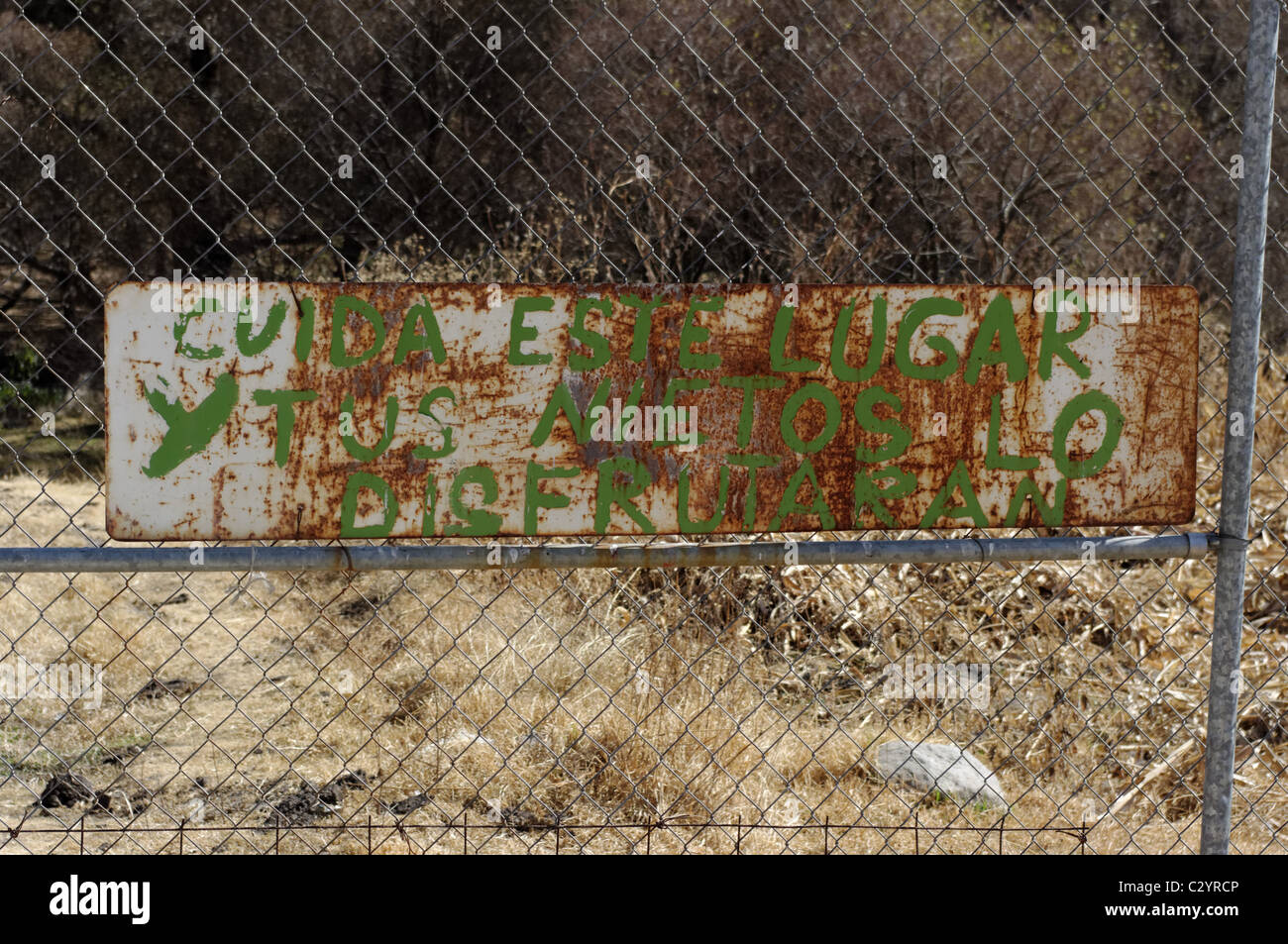 Old and rusted signpost that says in Spanish: 'Take care of this place and your grandsons will enjoy it' Stock Photo
