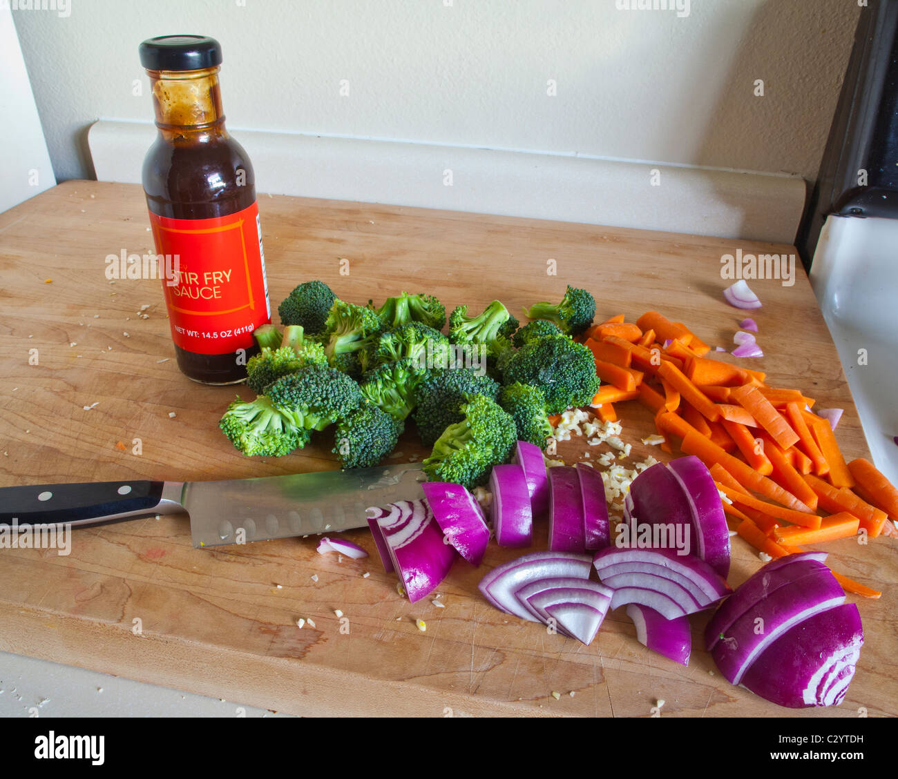 Cut up vegetables ready to be stir fried with a bottle of stir fry
