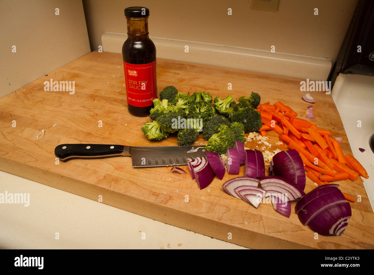 Cut up vegetables ready to be stir fried with a bottle of stir fry