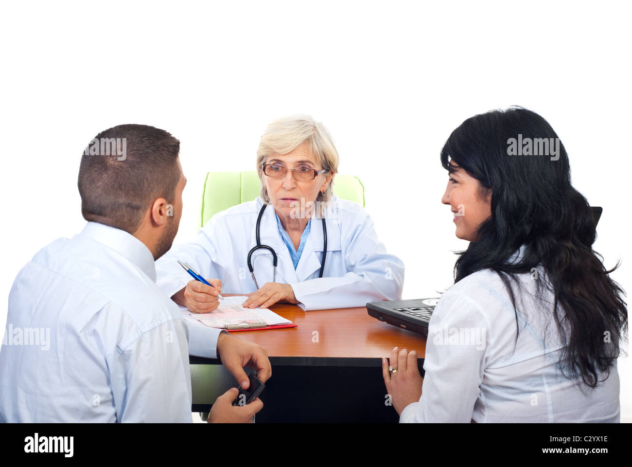 Senior doctor woman having conversation with young couple in office ...