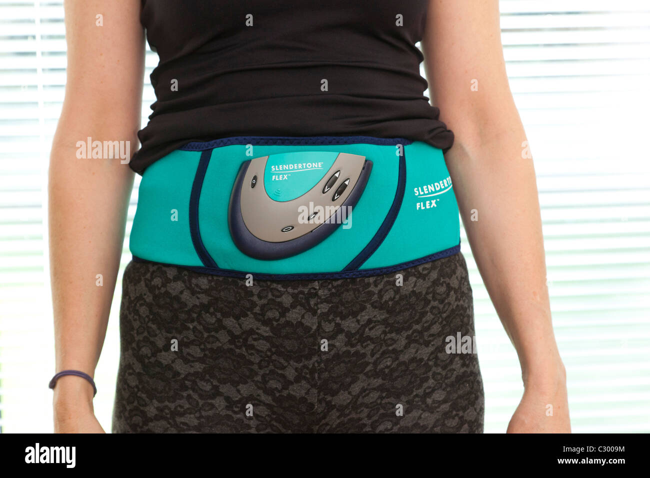 woman using Slendertone belt to tone her stomach Stock Photo - Alamy