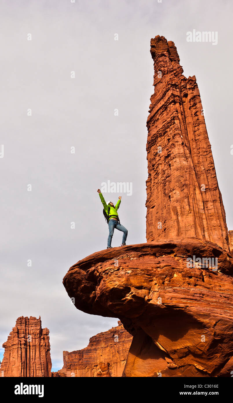 Hiker celebrates on the summit of a sandstone spire. Stock Photo