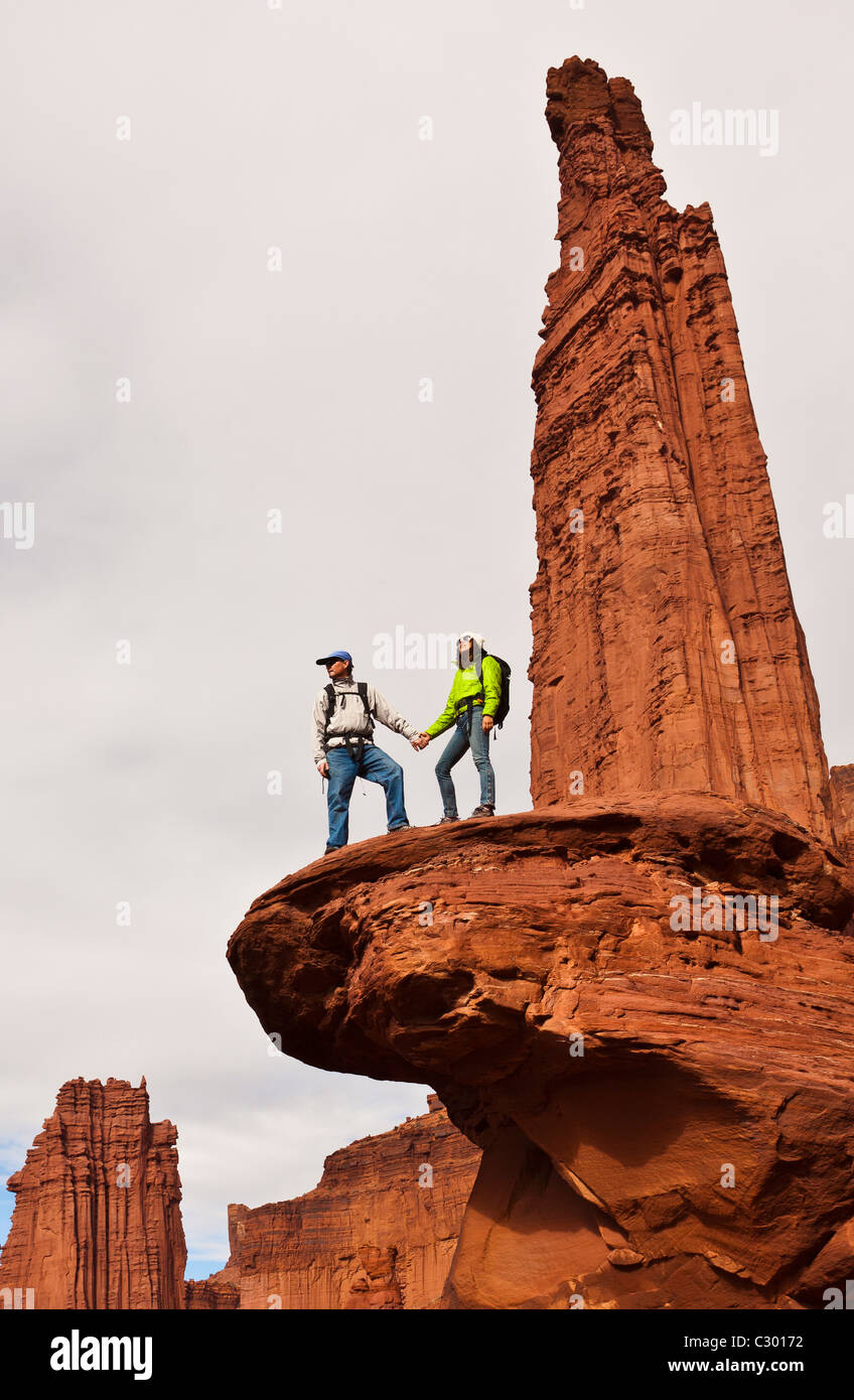 Team of hikers on the summit of a sandstone spire. Stock Photo