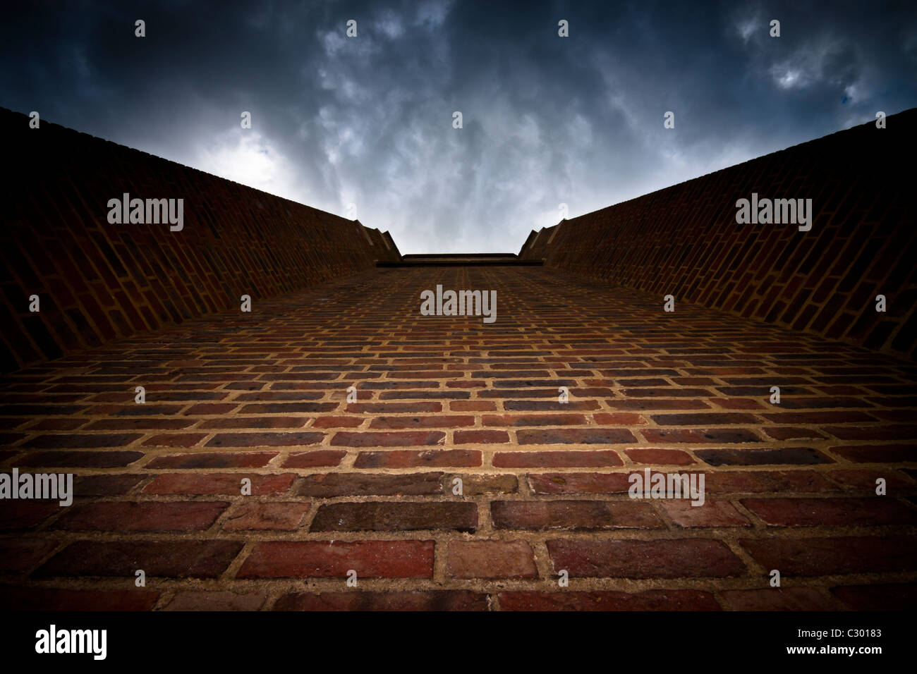 Abstract photo of brick wall and dramatic dark sky Stock Photo