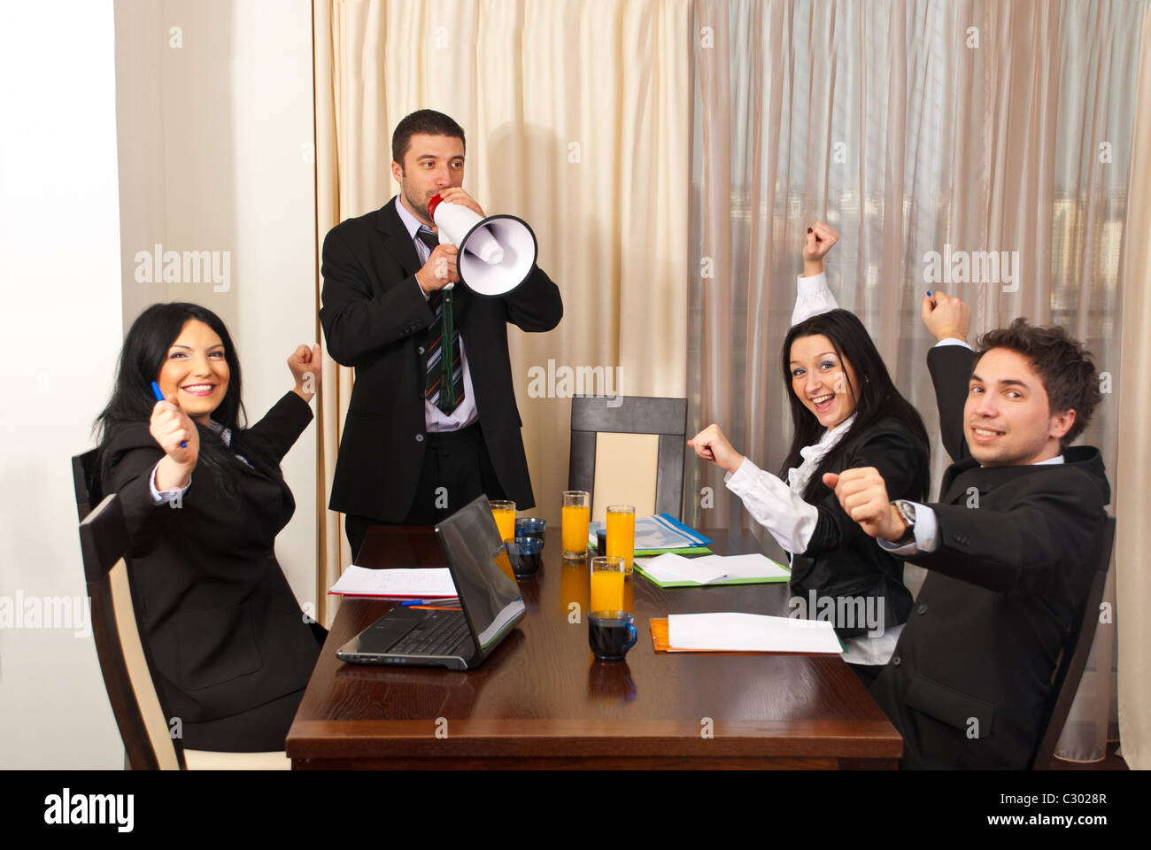 Manager with megaphone giving great news and all employees cheering and ...