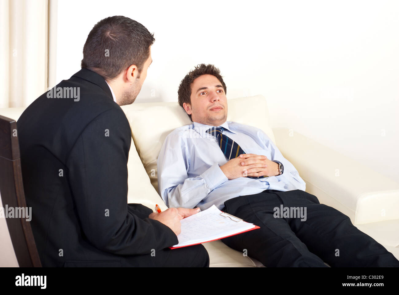 Psychiatrist man talking with hypnotized male patient Stock Photo