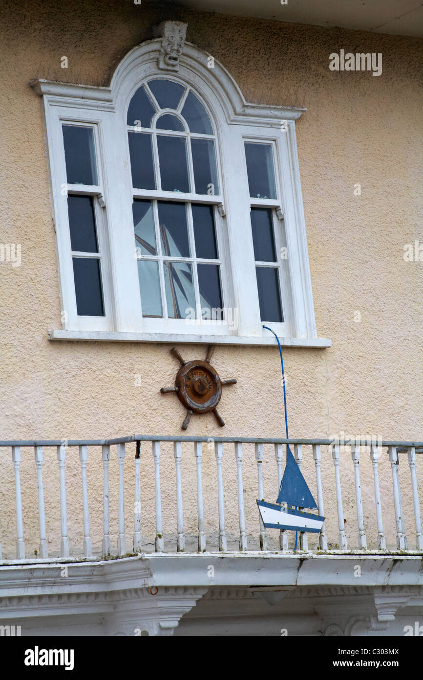 Boat in window and on veranda railings of house in West Bay in January Stock Photo