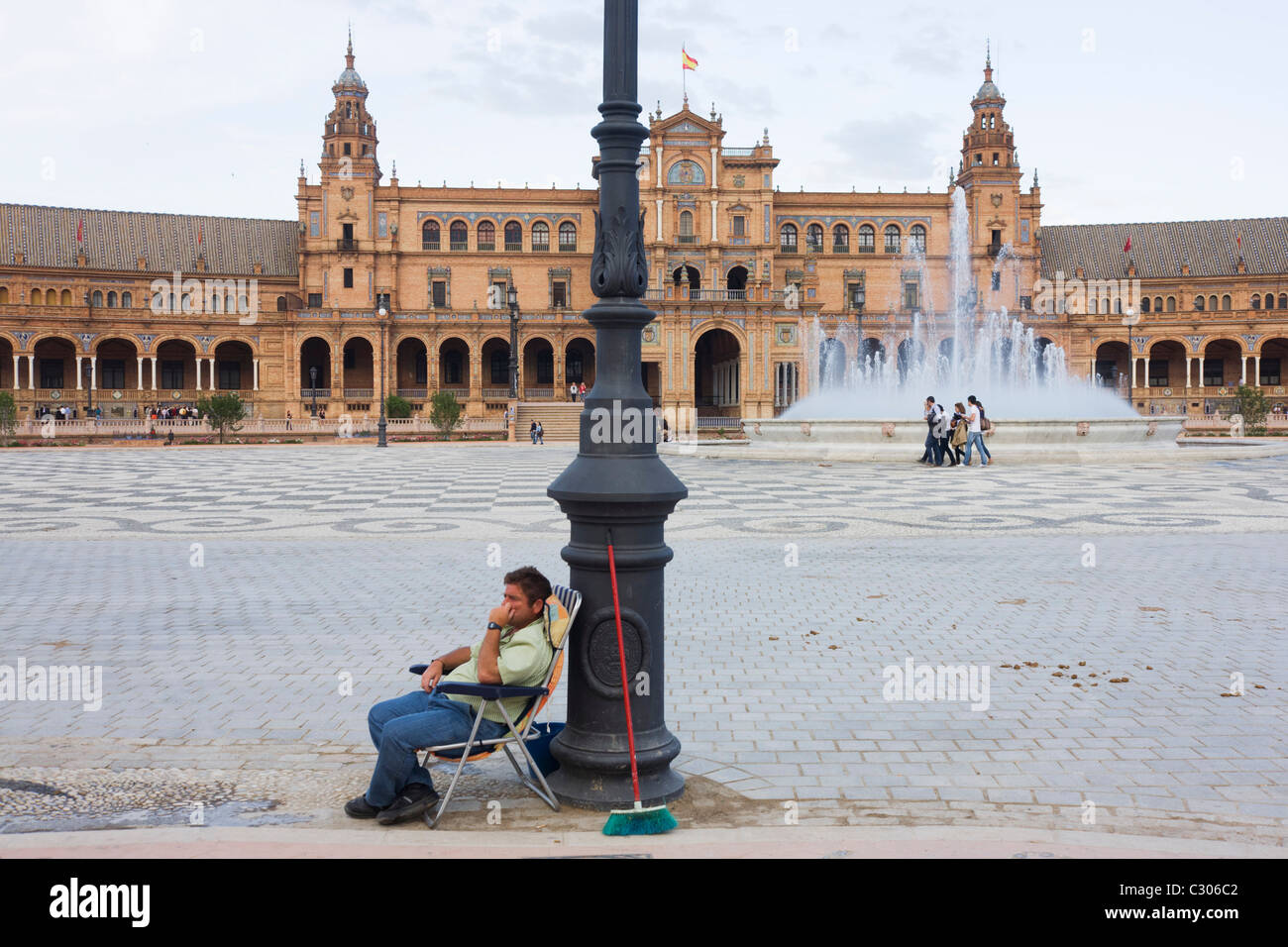 Doney ride owner awaits new business during quiet period in Seville's Plaza de Espana. Stock Photo