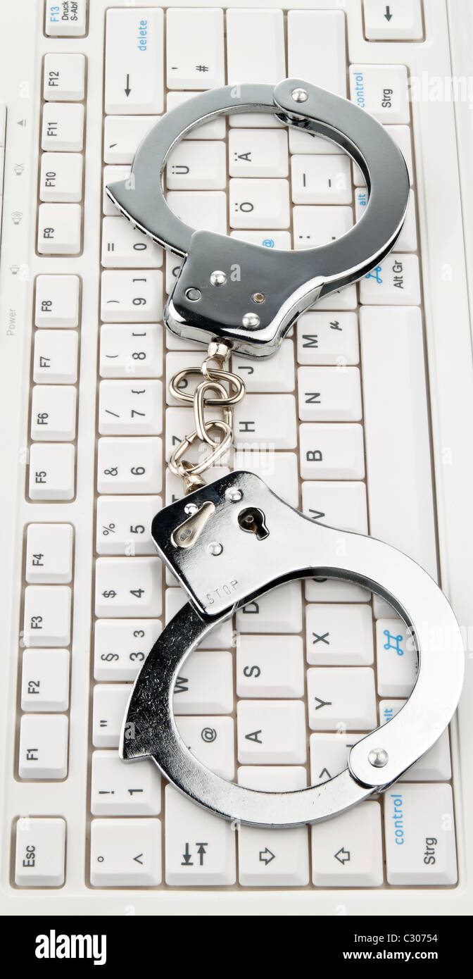 Computer keyboard handcuffs. Cyber crime. Stock Photo