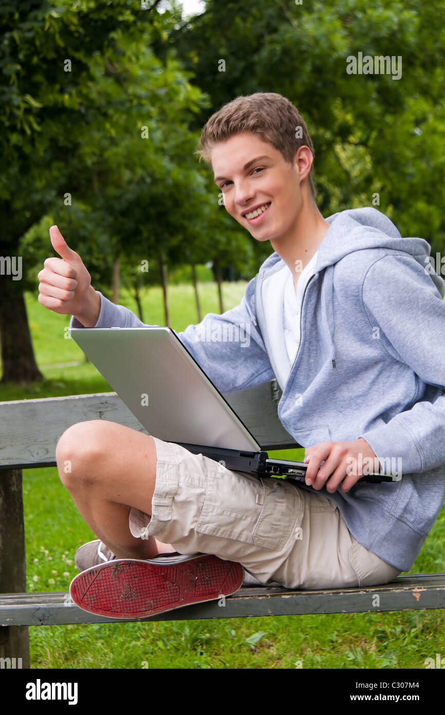 Young man with laptop computer outdoors Stock Photo