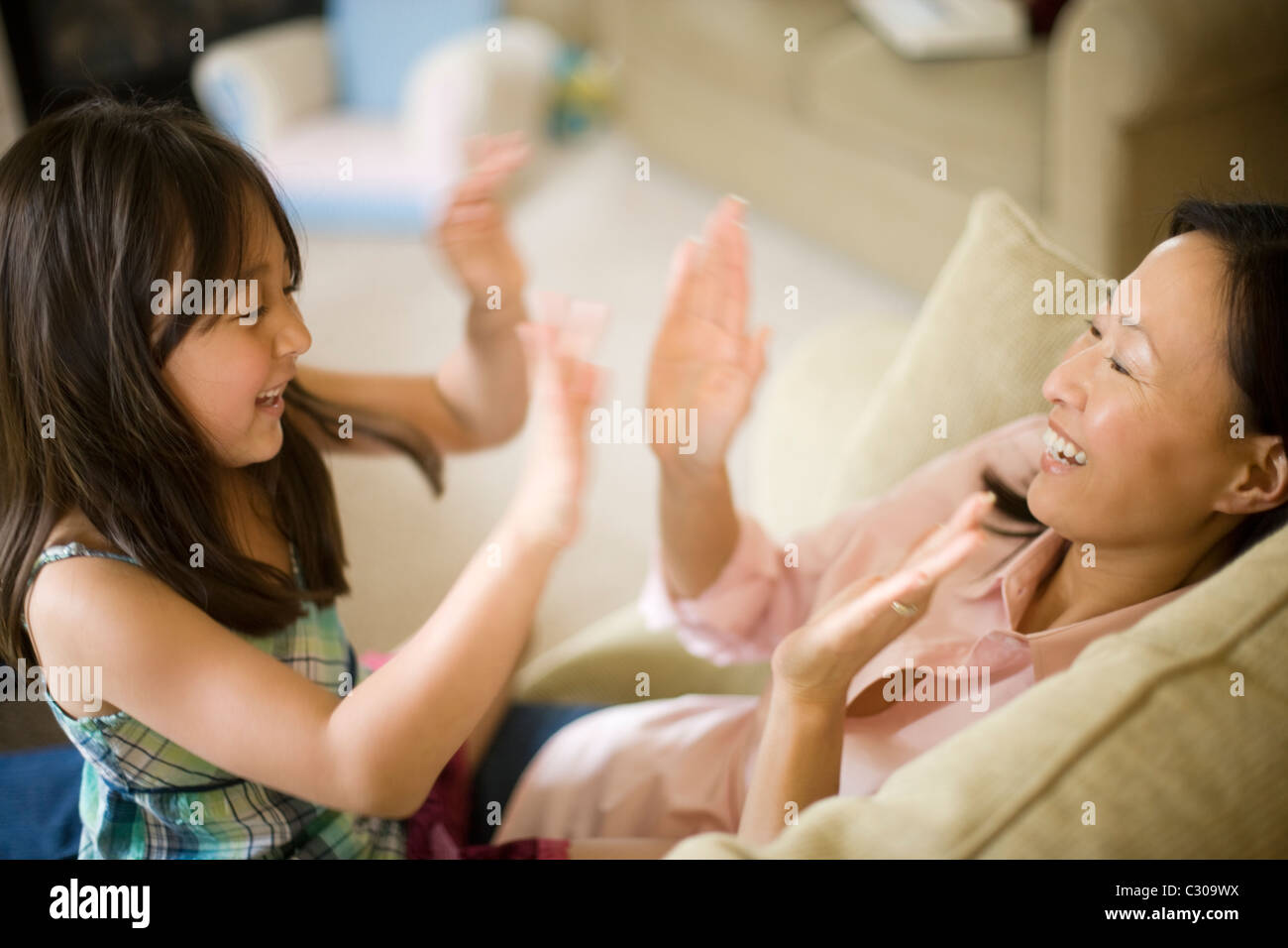Asian mother and daughter playing pattycake Stock Photo
