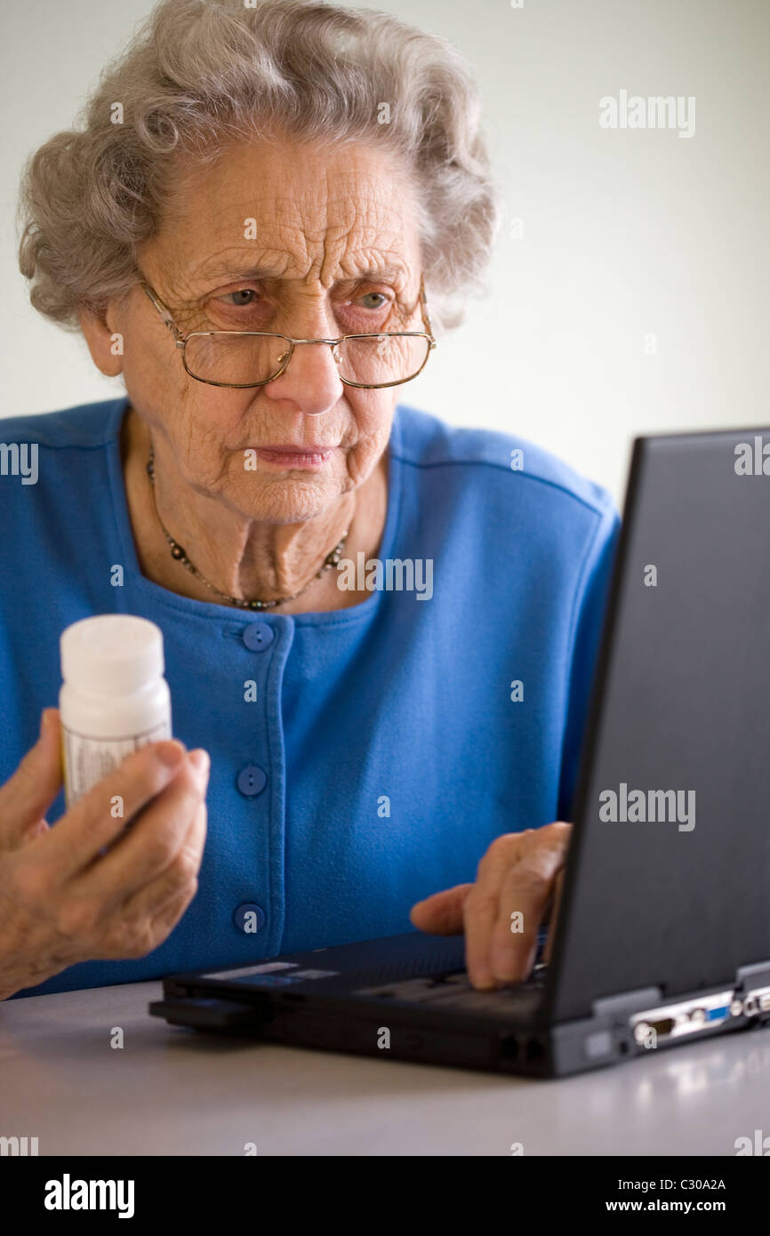 Senior woman researching prescription on-line Stock Photo