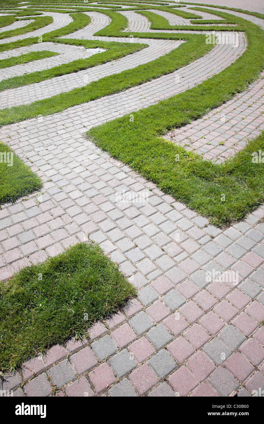 High angle view of the beginning of a maze with a cobblestone walkway and grass boundaries. Vertical shot. Stock Photo