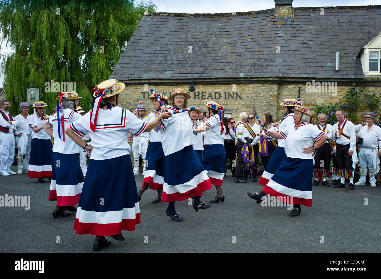 England's Glory Ladies Morris dancers perform a dancing display at The Kings Head Pub in Bledington, Oxfordshire, UK Stock Photo