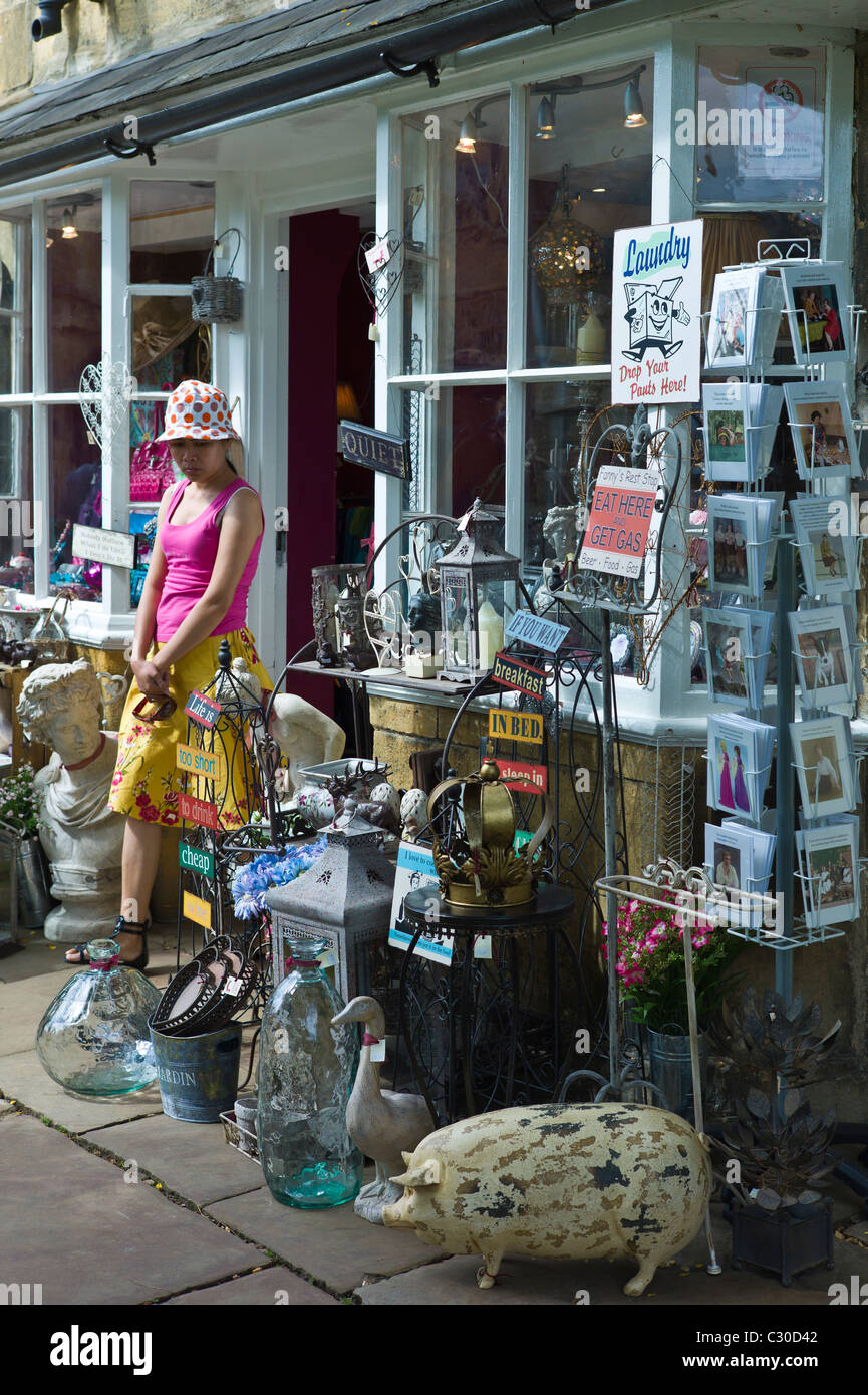 Tourist leaving curiosity shop selling souvenirs, collectibles and gift items in Chipping Campden, The Cotswolds, UK Stock Photo