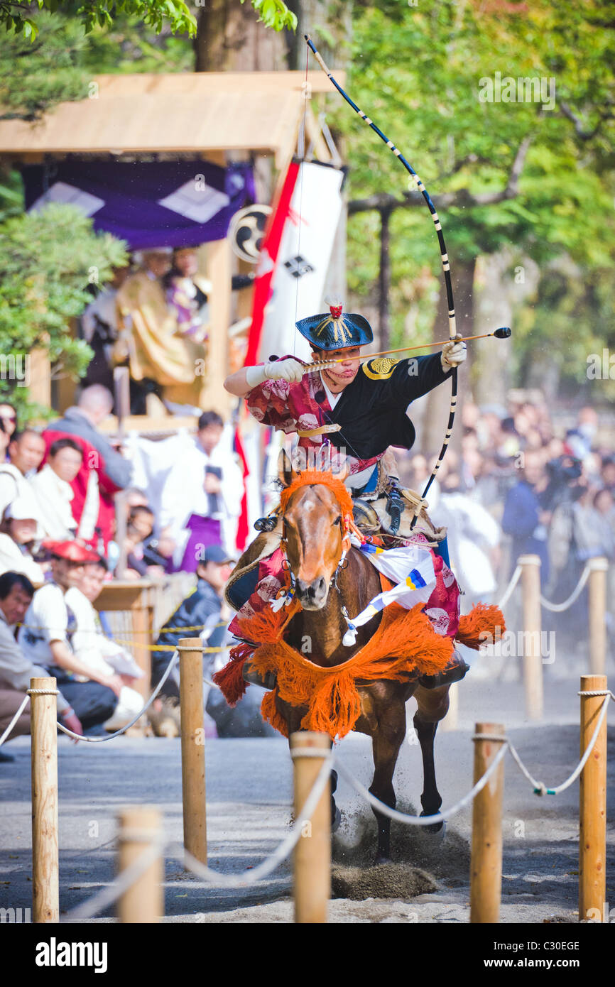 An Archer in Ancient Samurai Costume Prepares to shoot an arrow during a Horseback archery