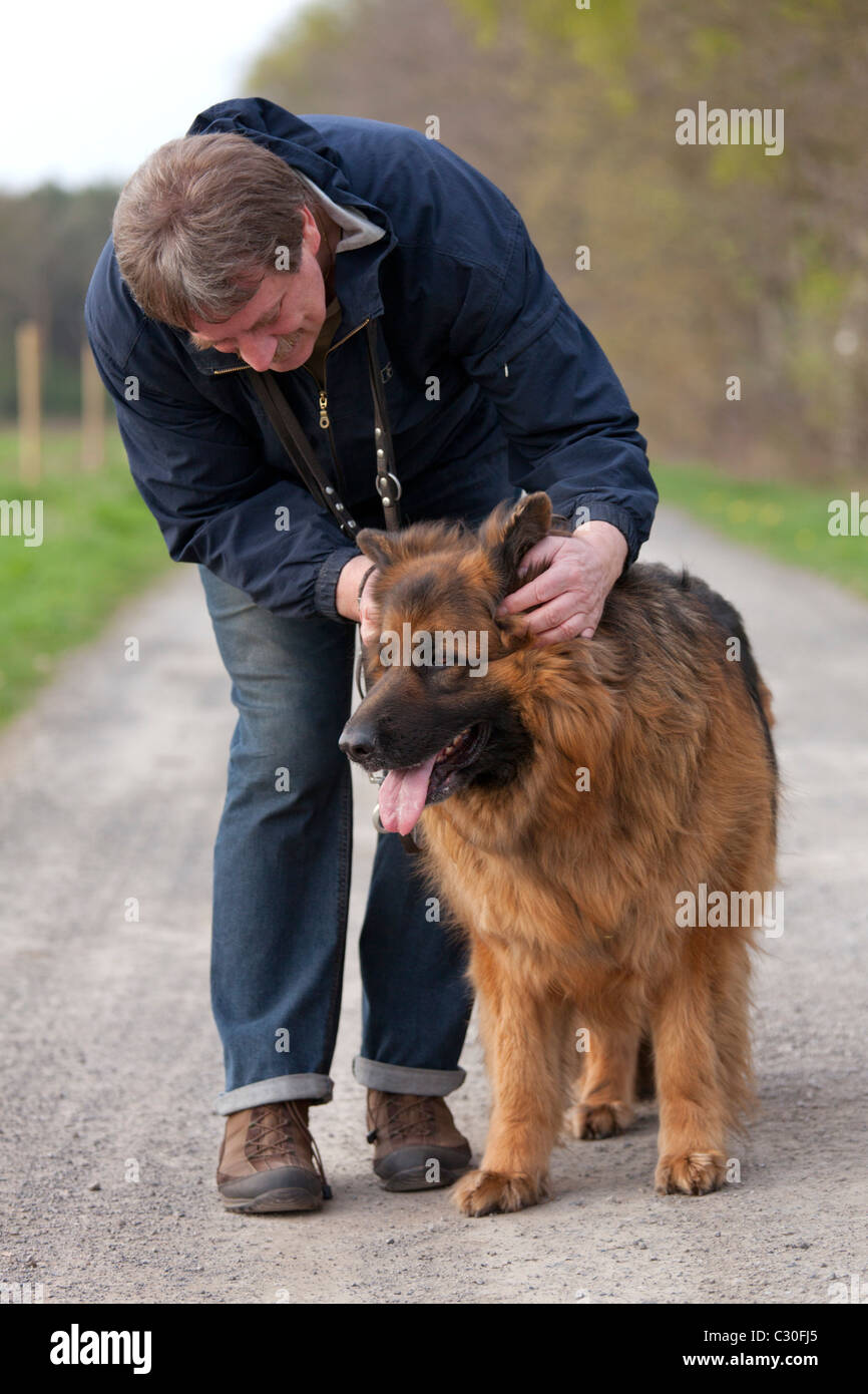 a man with his Long Hair German Shepherd Dog Stock Photo - Alamy