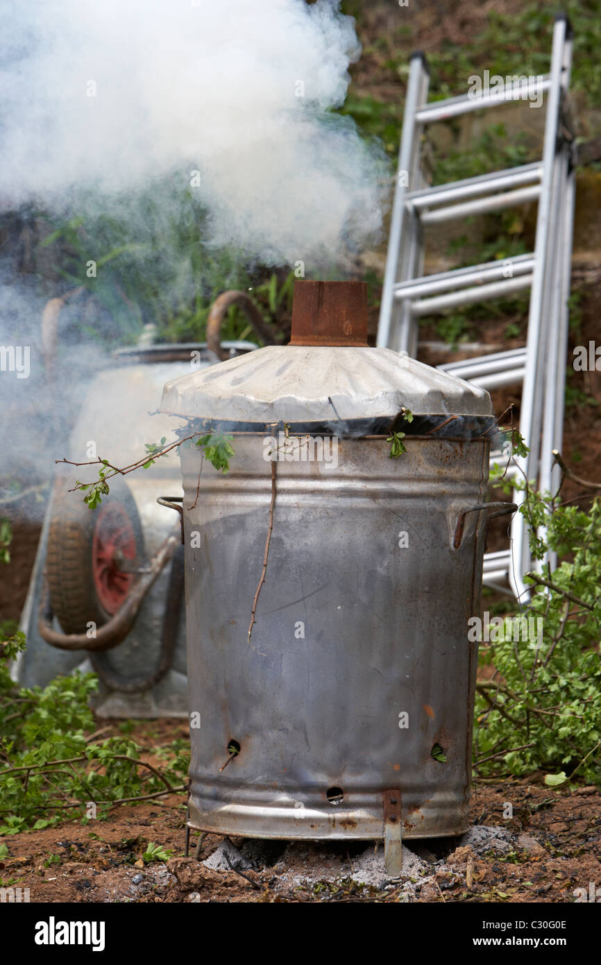 home garden incinerator burning green tree and bush waste during