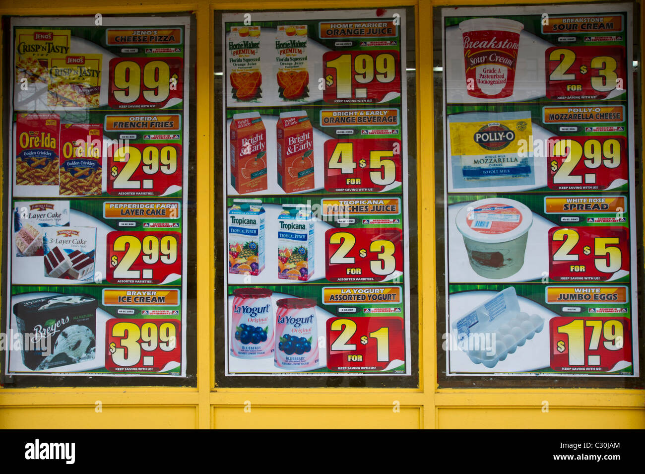 Sale signs for groceries seen in a supermarket window in the