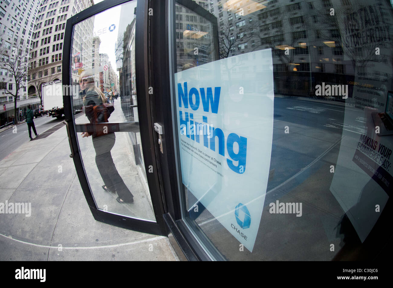 A Now Hiring sign in the window of a JP Morgan Chase branch in Lower Manhattan on Friday, April 15, 2011. (© Frances M. Roberts) Stock Photo