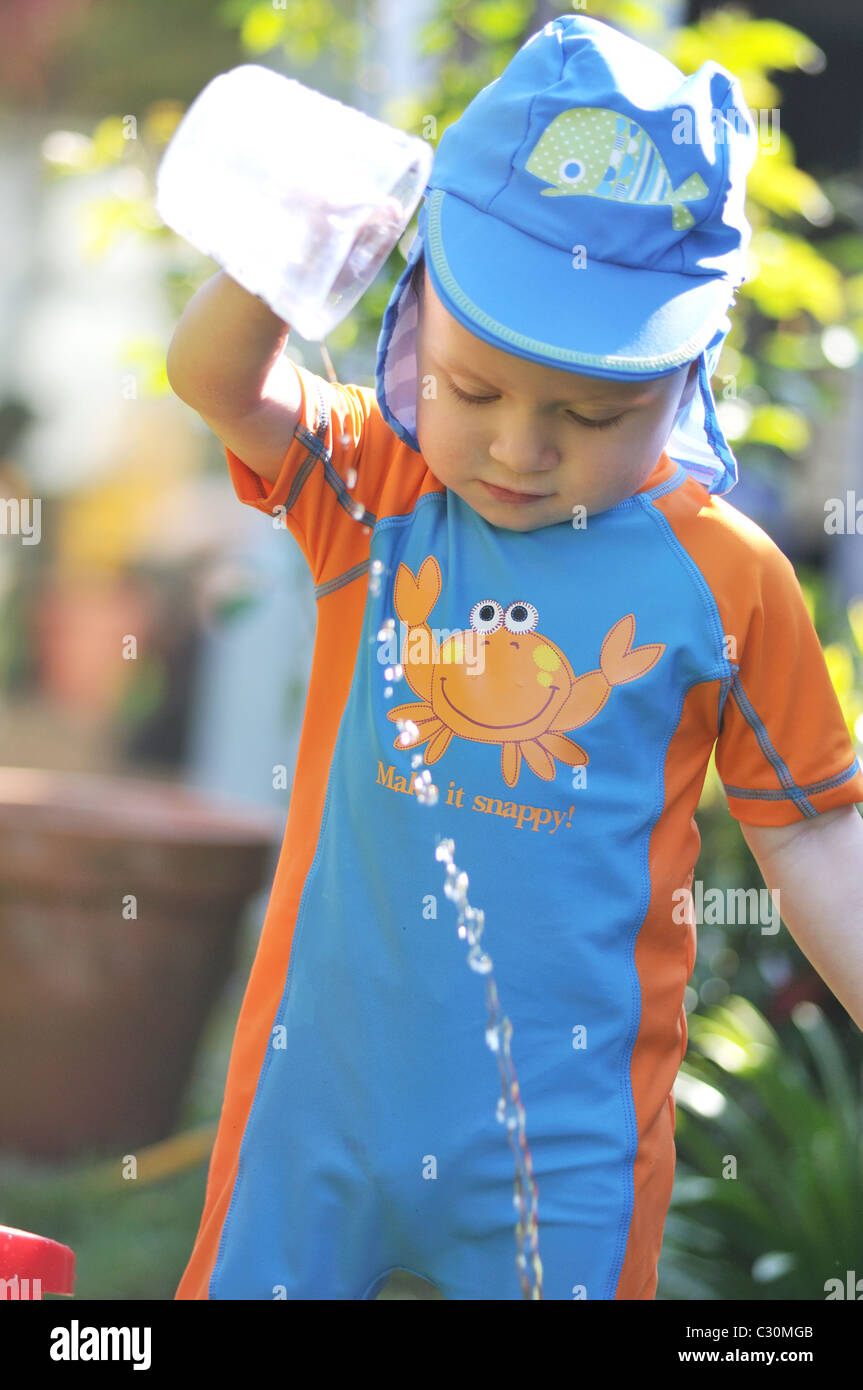 Little 18 months old boy playing with a jug and water Stock Photo Alamy