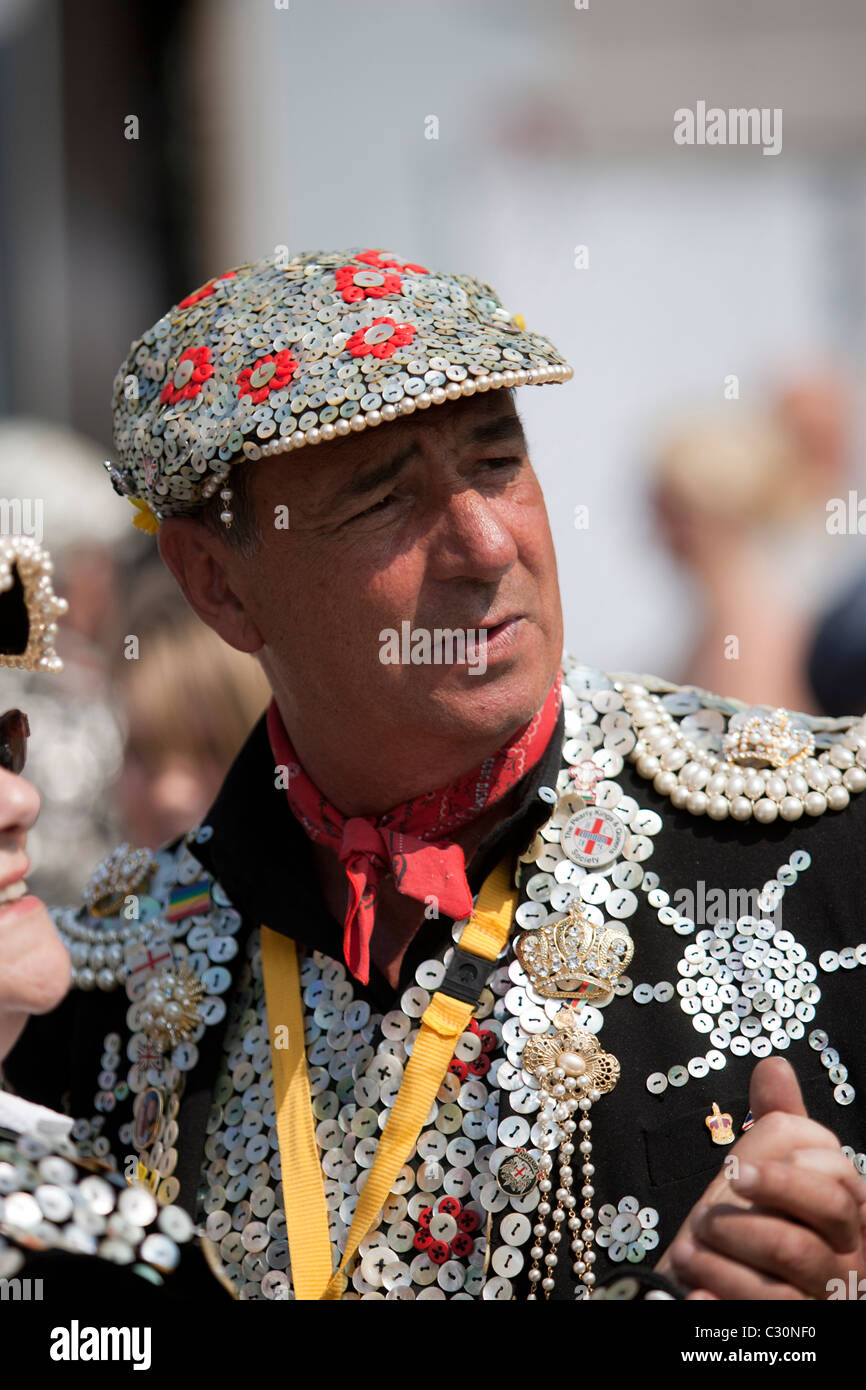 Pearly King of Wapping dancing with Pearly Queen of Highgate in traditional  costume St Georges Day Stock Photo - Alamy