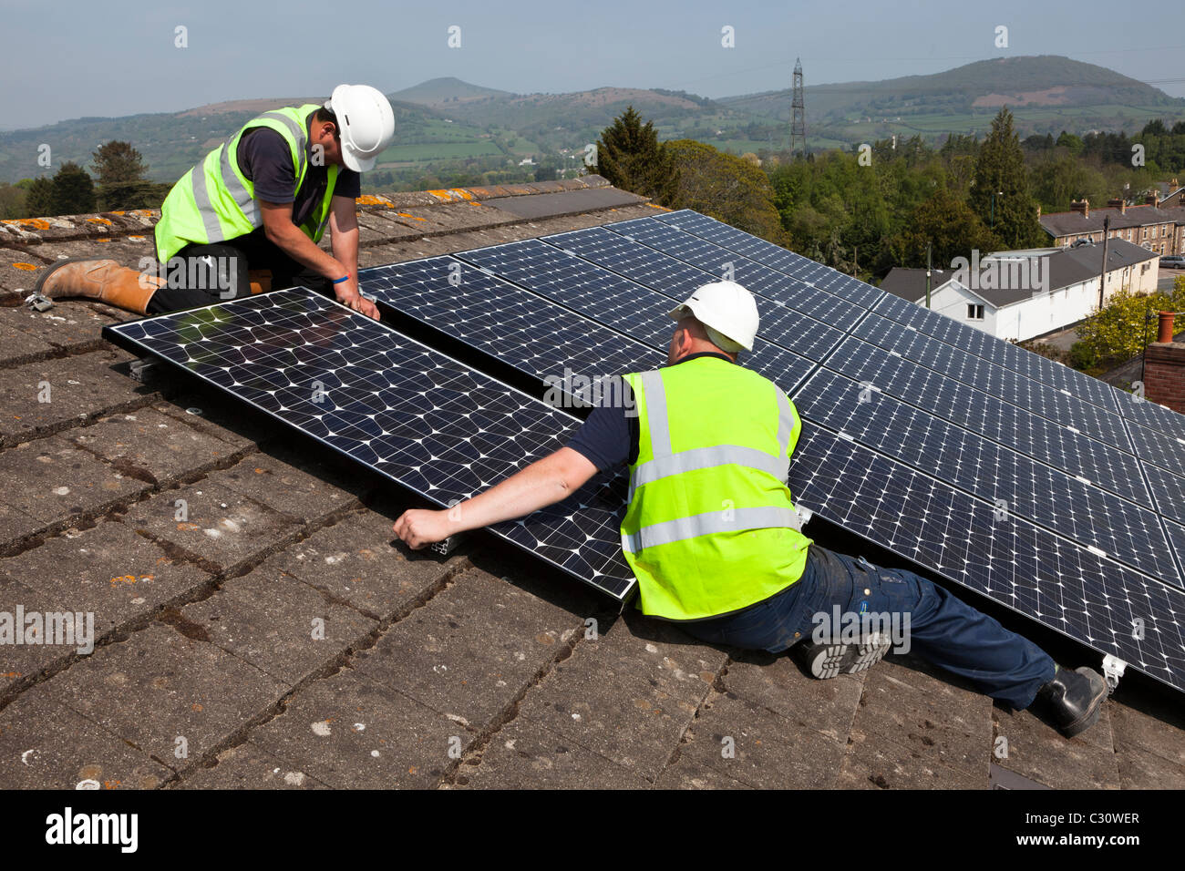 Fitting solar pv panels to a house roof Wales UK Stock Photo