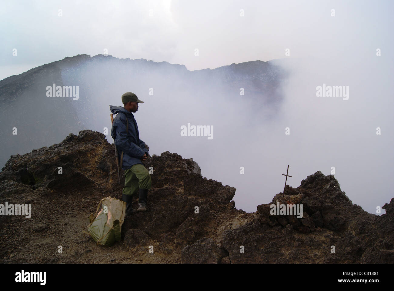 Virungas National Park, DRC: A park ranger stands at the mouth of Nyiragongo, one of the most active volcano's on earth. Stock Photo