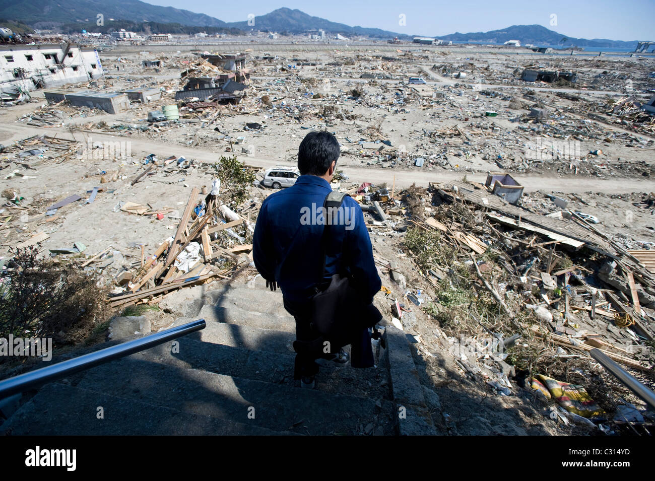 Michihiro Kohno, president of soy sauce and miso soup maker Yagisawa Shoten, looks over the wreckage that includes his family's 207-year-old company in Rikuzentakata, Japan Stock Photo