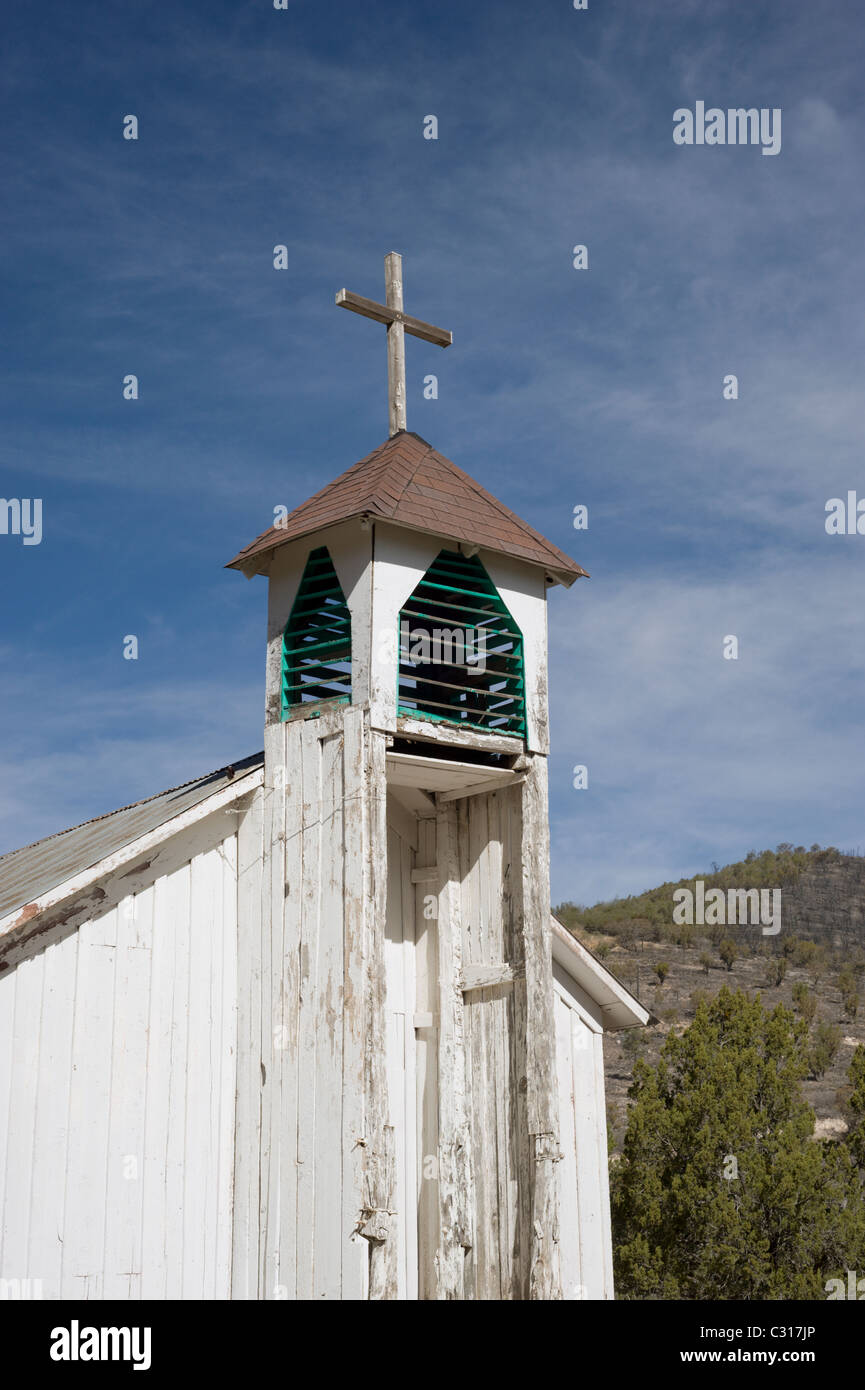 The old wooden bell tower of San Ysidro church reaches to the blue heavens in the Hondo Valley, New Mexico. Stock Photo