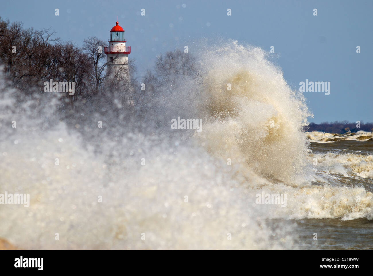 Waves crashing over the rocks in front of Marblehead Light on Lake Erie Stock Photo