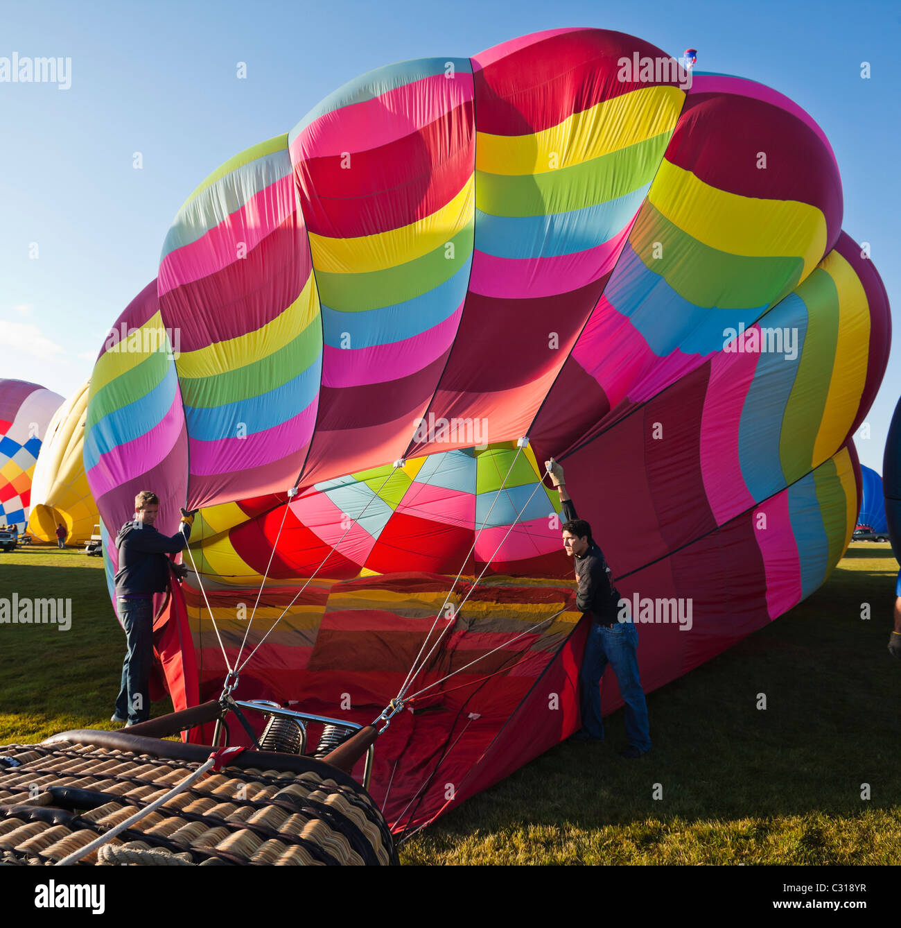 Two men holding the balloon open as it fills up with air. Albuquerque, New Mexico, USA. Stock Photo