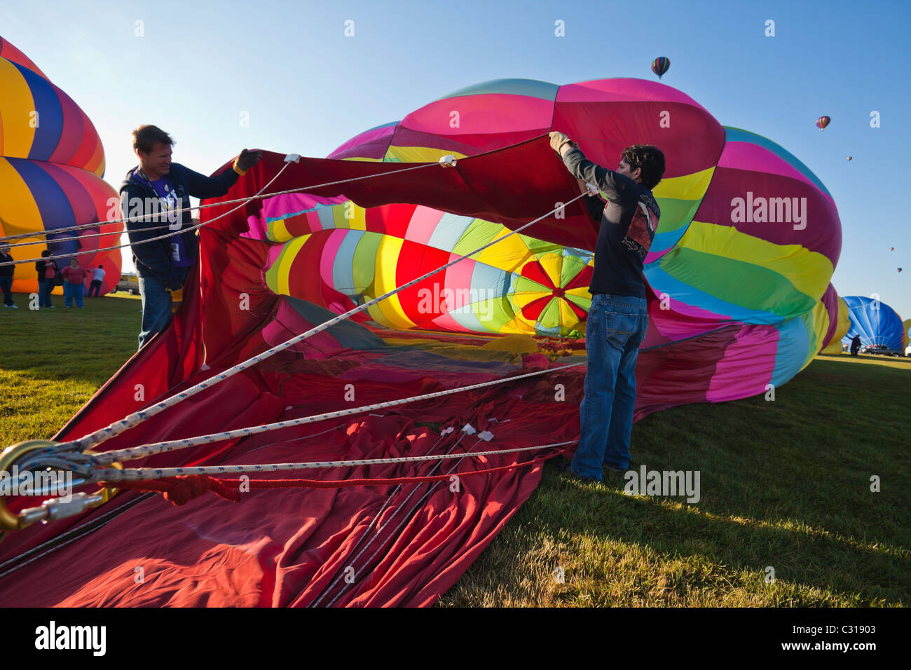 Two men holding the balloon open as it fills up with air. Albuquerque, New Mexico, USA. Stock Photo