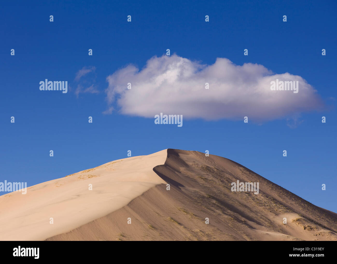 Cloud over desert sand dune - Kelso Dunes, Mojave desert, California USA Stock Photo