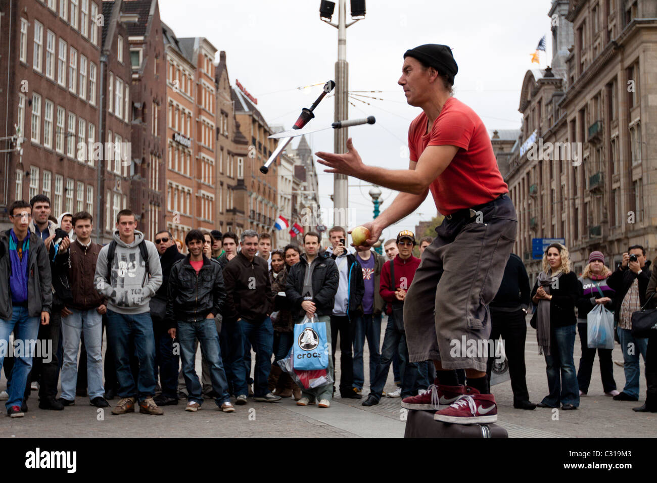 A Street Entertainer Does His Act For A Crowd Of Tourists Who Have 