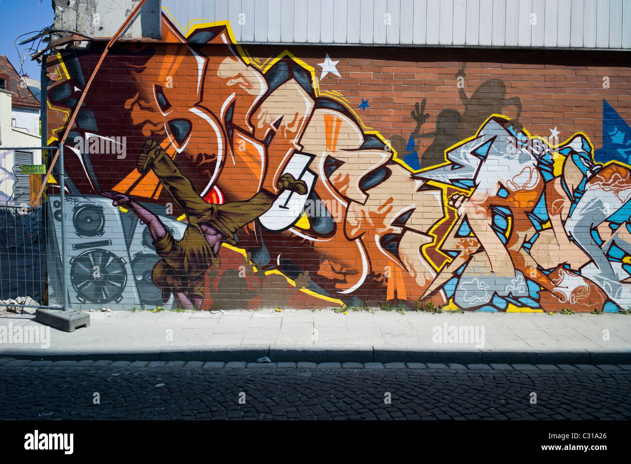 Artful graffiti on a long brick wall in Munich-Giesing showing a colorful tag and different elements of hip hop culture, Germany Stock Photo