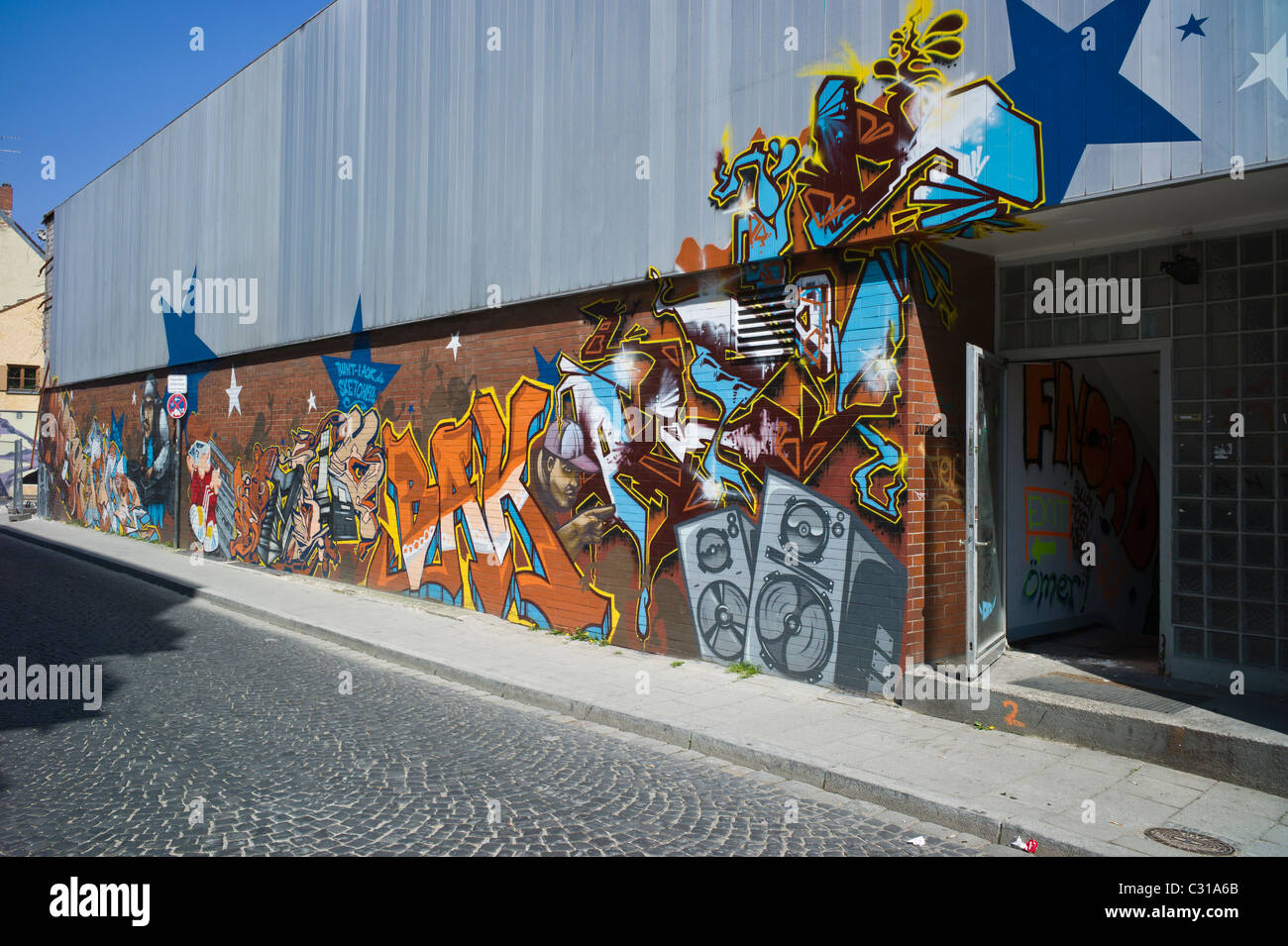 Artful graffiti on a long brick wall in Munich-Giesing showing a colorful tag and different elements of hip hop culture, Germany Stock Photo