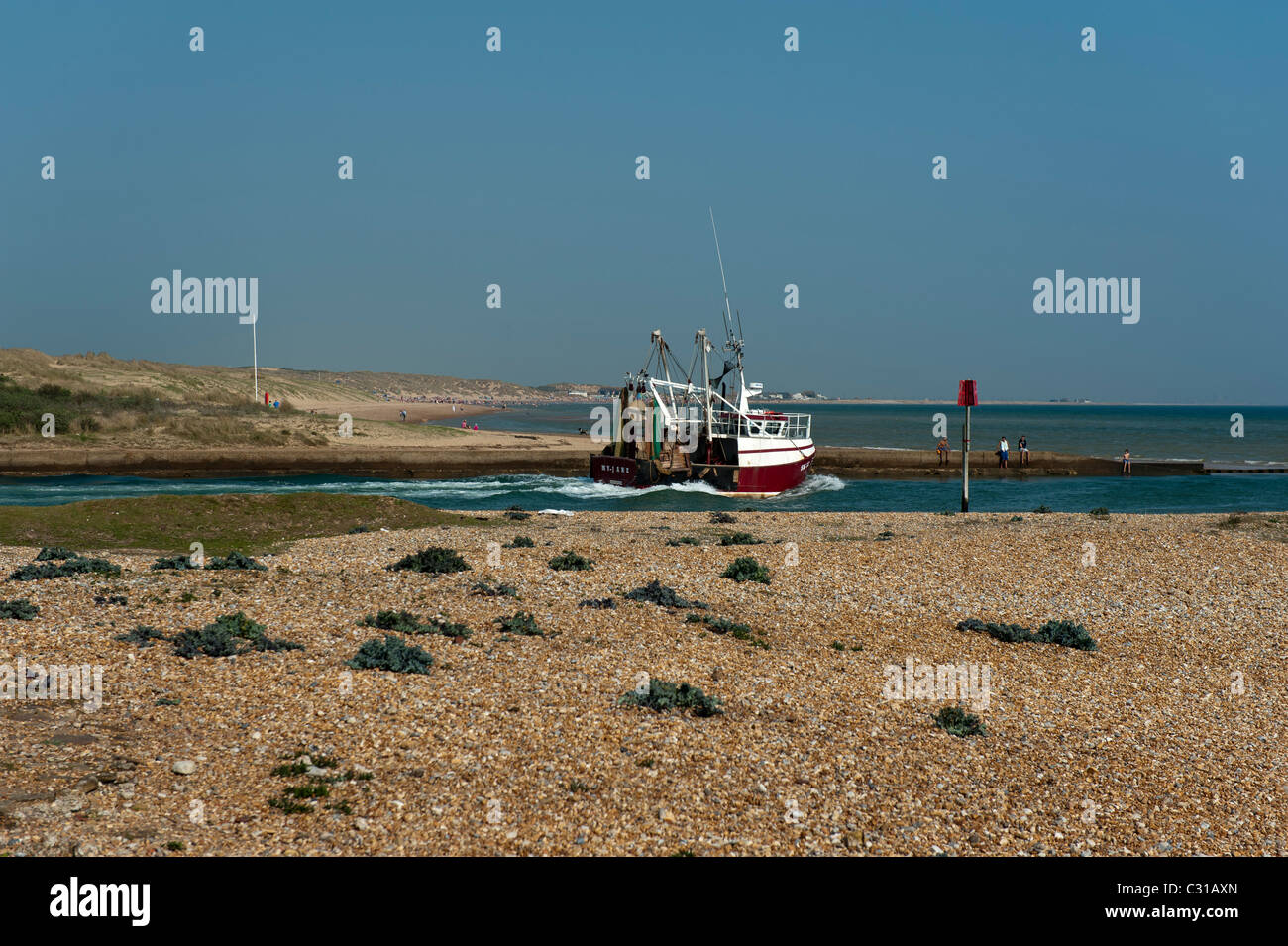 Fishing boat leaving Rye Harbour East Sussex England UK Stock Photo