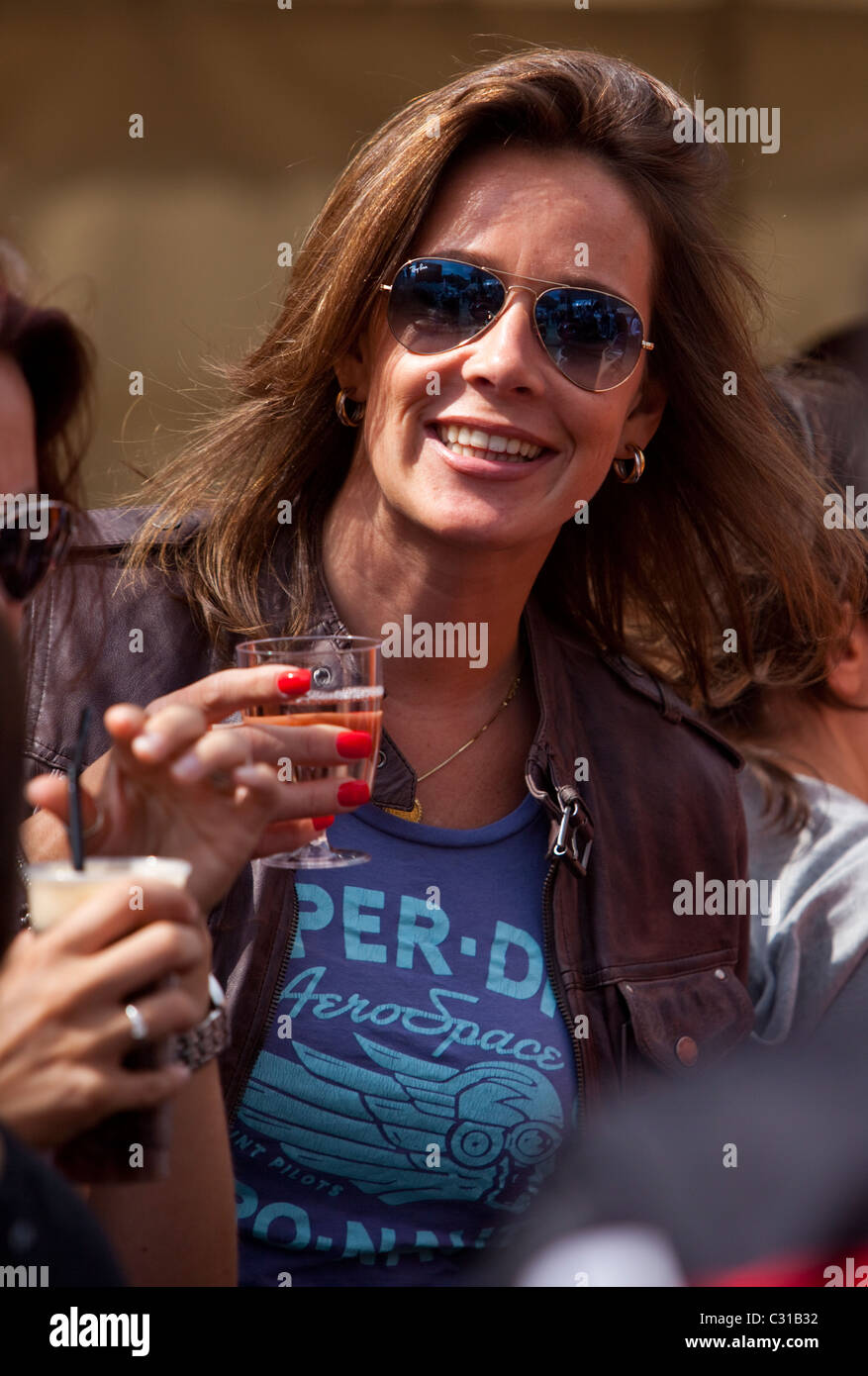 Portrait of a woman wearing sunglasses and holding a glass of wine, London, England, UK. Stock Photo