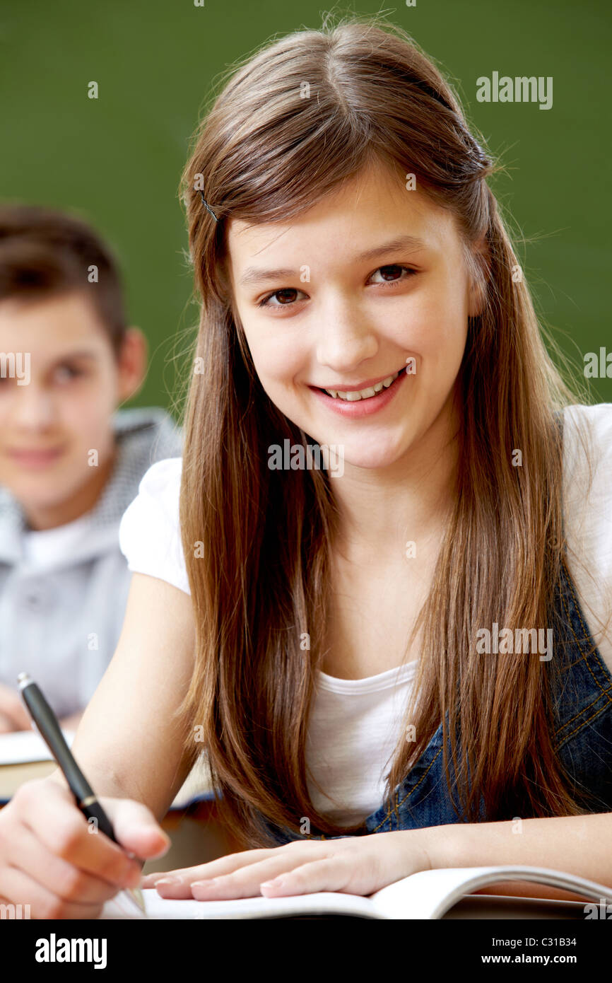 Portrait of pretty girl with pen at workplace looking at camera Stock ...