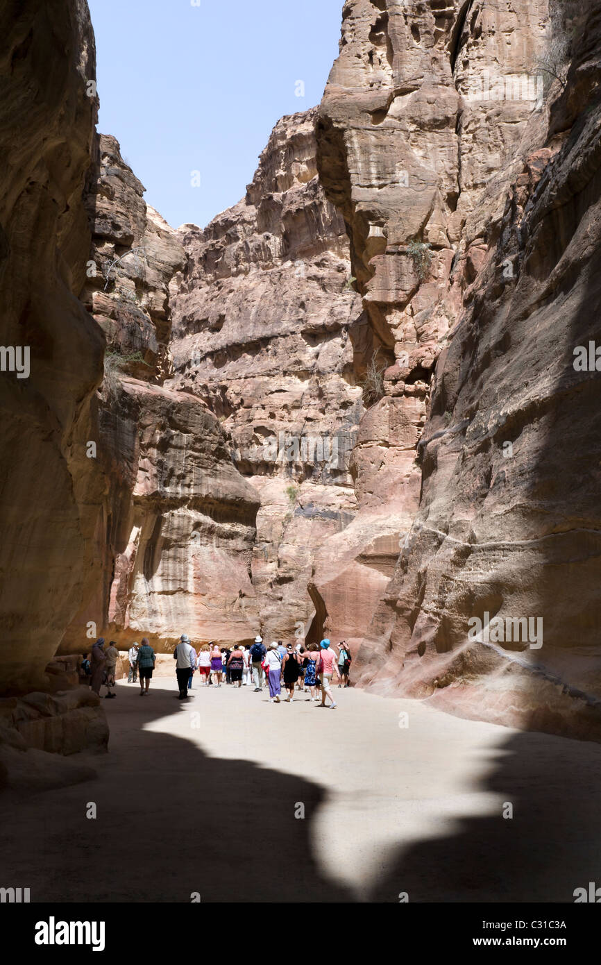 TOURISTS WALK DOWN THE SIQ TO THE ROSE RED CITY AT PETRA. JORDAN Stock Photo