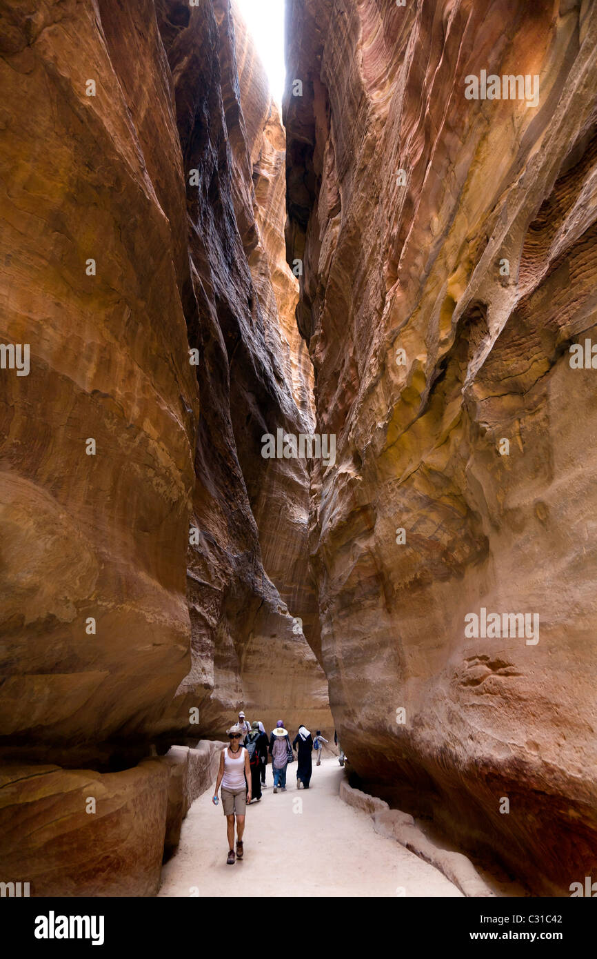 TOURISTS WALK DOWN THE SIQ TO THE ROSE RED CITY AT PETRA. JORDAN Stock Photo
