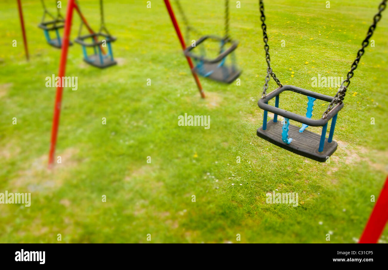 Swings without children, a reminder of childhood from the playground. Stock Photo