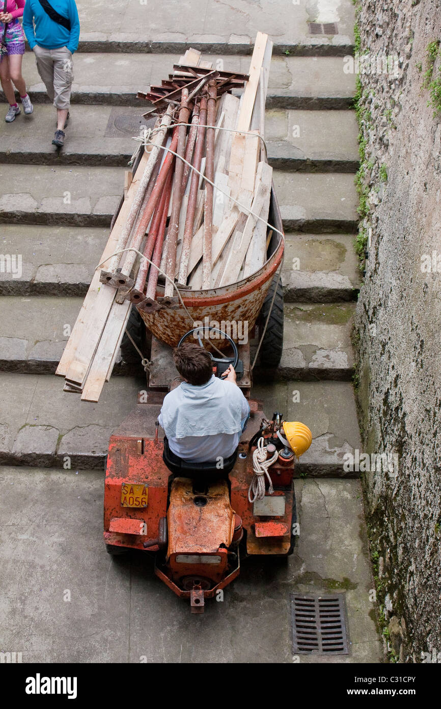 Worker reverses down steps in Ravello, Italy. Stock Photo