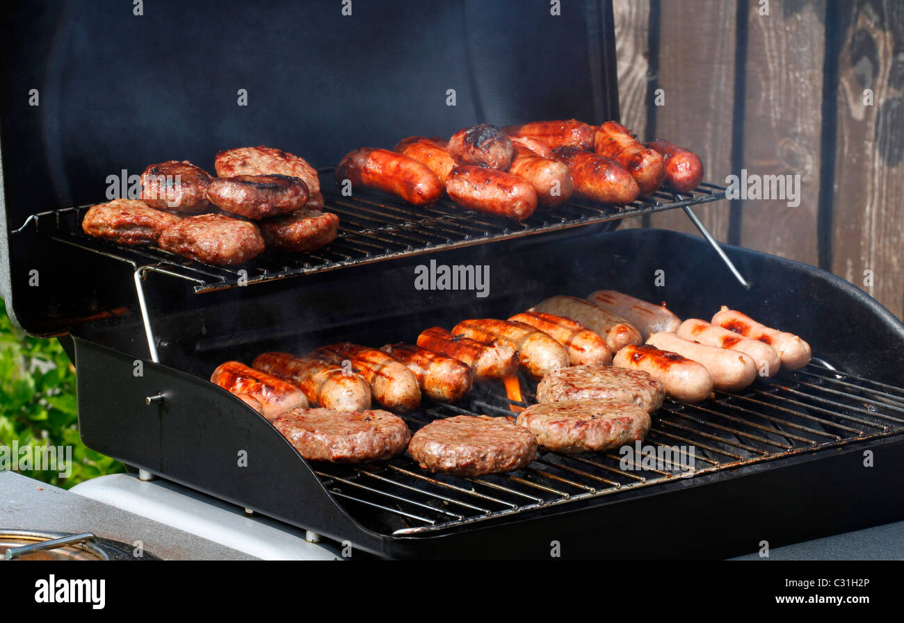 Sausages and burgers being cooked on a barbecue Stock Photo Alamy