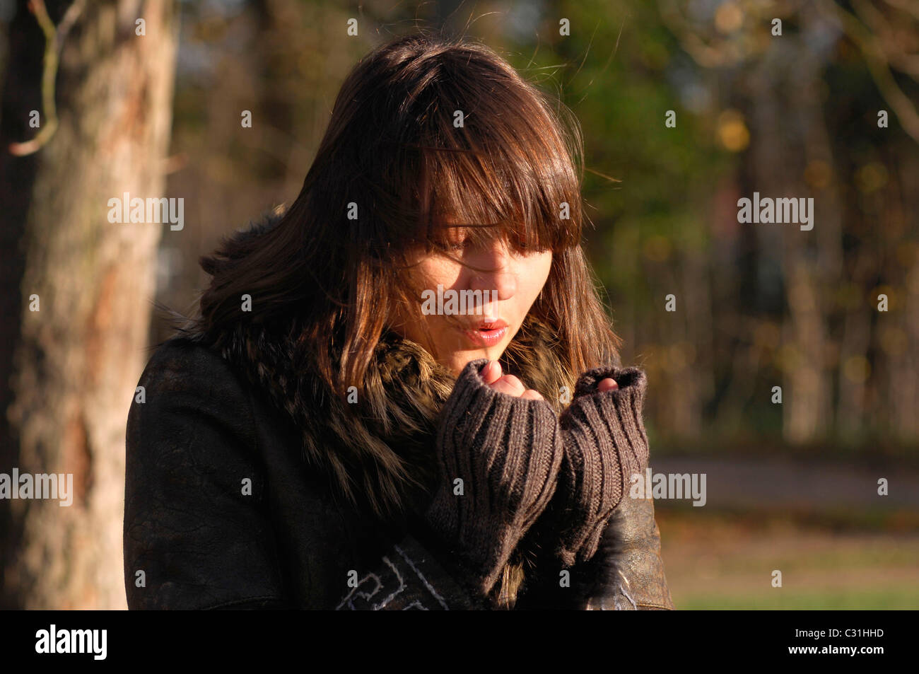 THE COLD. YOUNG WOMAN WARMING HER FINGERS Stock Photo Alamy