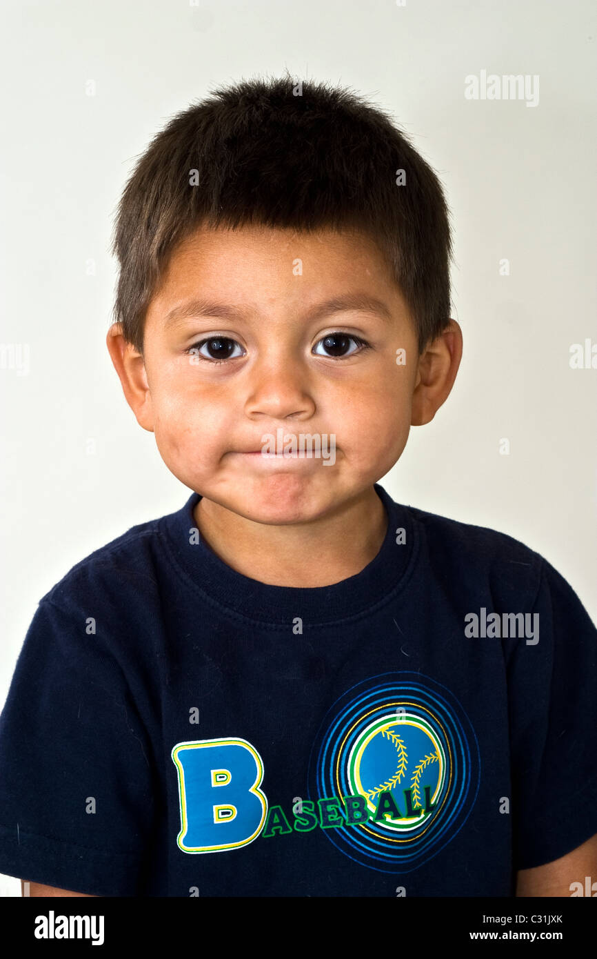 Stubborn strong willed little boy won't talk 4-5 year old Hispanic boy portrait eye contact looking at camera making pulling face MR © Myrleen Pearson Stock Photo