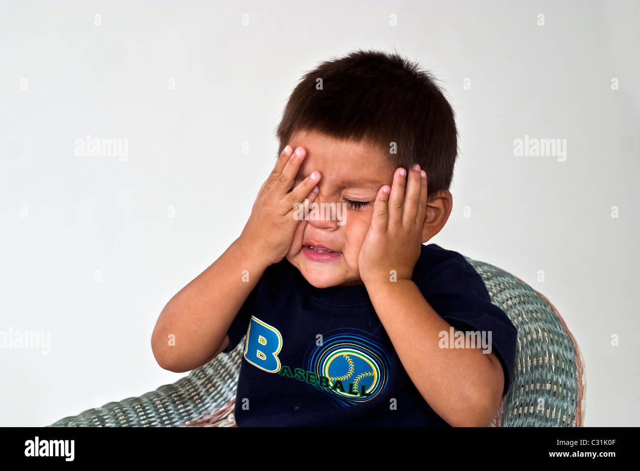 Tired bored 4-5 year old Hispanic American boycotter his eyes for portrait. MR © Myrleen Pearson Stock Photo