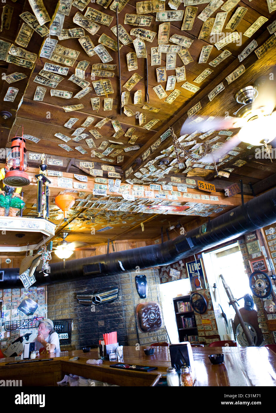 Signed one dollar bills tacked on the ceiling and walls of western bar